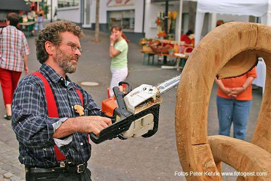 Bild vergrößern: Zu sehen ist die Bearbeitung einer Holzskulptur mit der Kettensäge durch Herrn Mengel während des Holzmarktes.
