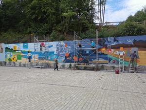 Bild vergrößern: Außenparkplatz des Zentrums Via Adrina in Arfeld. Die ausgewählte Wand wird von den Jugendlichen mit dem selbst gestalteten Motiv besprüht.
