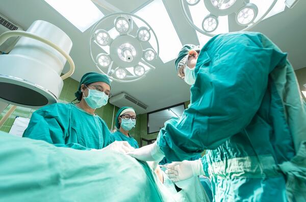 Bild vergrößern: Mehrere Ärzte sind in einem Operationssaal zu sehen.
