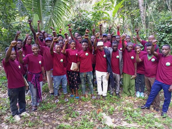 Bild vergrößern: Gruppenbild der Landwirtinnen und Landwirte, die am Workshop an der nachhaltigen Landwirtschaftsschule in Morogoro teilgenommen haben. Alle haben ein rotes T-Shirt der Schule an und heben ihre Faust nach oben.