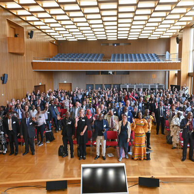 Bild vergrößern: Gruppenbild aller TeilnehmerInnen der Afrika Konferenz im großen Konferenzsaal der Stadt Dresden. Teilweise erkennt man Personen mit traditionell afrikanischen Gewändern.