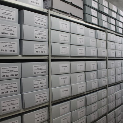 Bild vergrößern: Zu sehen ist eine mit Archivierungsboxen gefüllte Regalwand in einem Raum des städtischen Archives.