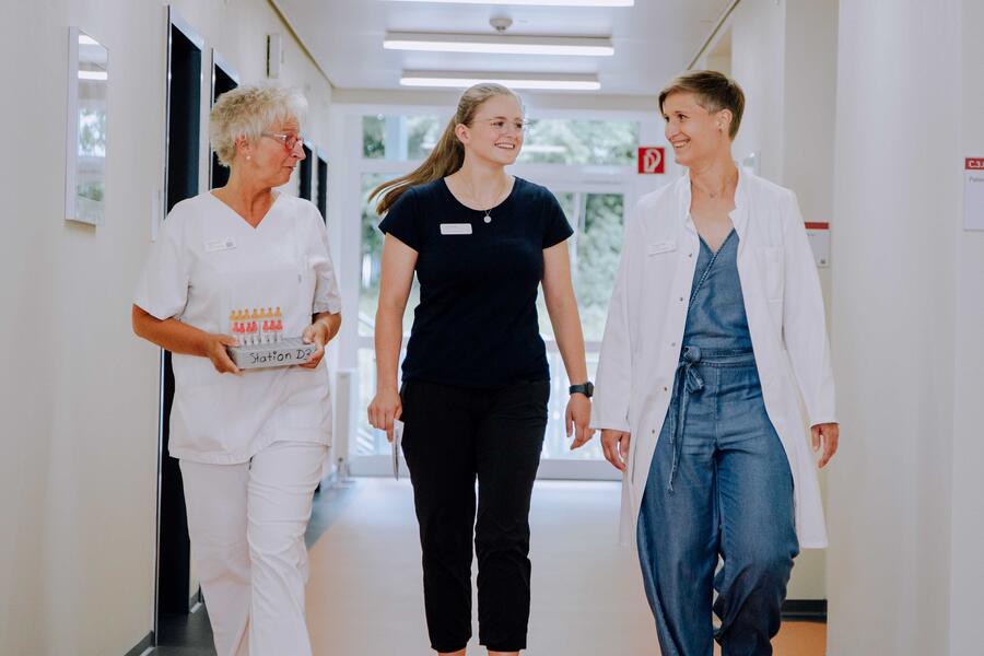 Bild vergrößern: Im Bild sieht man drei Mitarbeiterinnen der VAMED Klinik in weißer Bekleidung und eine Therapeutin in dunkelblau gekleidet.
