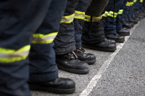 Bild vergrößern: Eine Reihe Feuerwehrleute steht zum Einsatz bereit, es sind nur die Stiefel zu sehen.