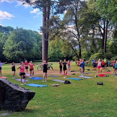 Bild vergr&ouml;&szlig;ern: Im Bild sieht man eine gro&szlig;e Anzahl von Sportler*innen bei Sport im Park in einer stehenden Position.