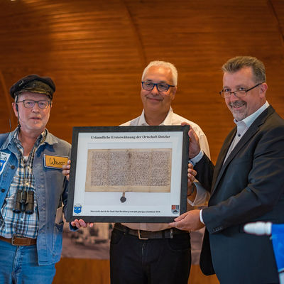 Bild vergrößern: Bürgermeister Bernd Fuhrmann überreicht Ortsvorsteher Dirk Jung eine Urkunde anlässlich der Dorfjubiläums