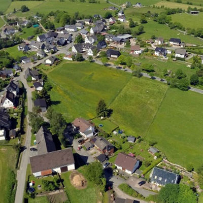 Bild vergrößern: Die Luftaufnahme zeigt die Ortschaft Sassenhausen umgeben von grünen Weiden.